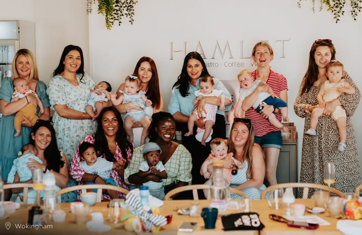 Diverse group of mothers with their babies gathered together at a café, warm and genuine community connection